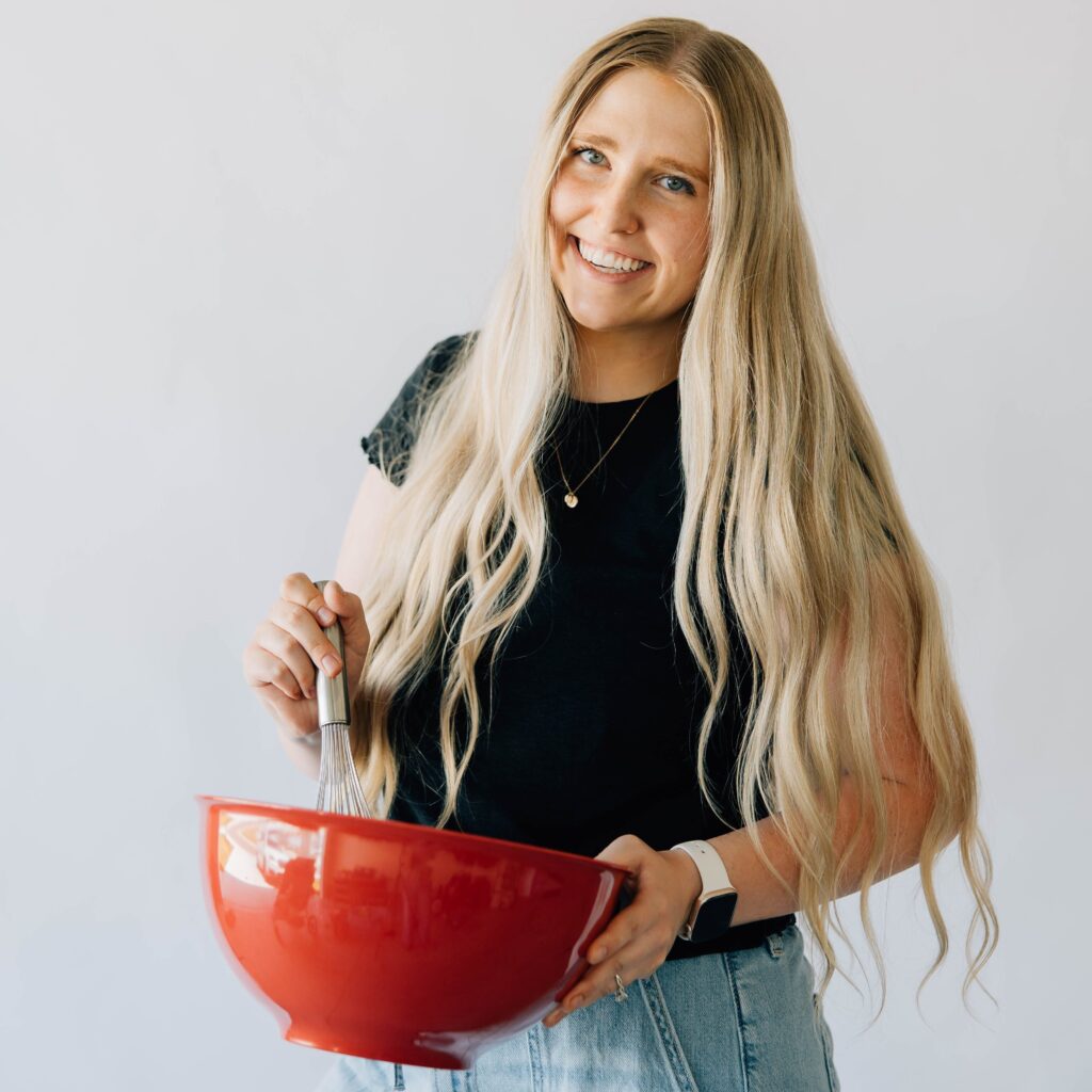 Portrait of Kenna holding a red bowl and a whisk