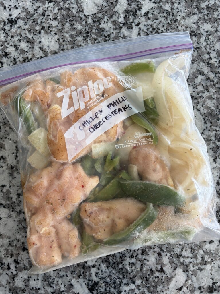 Labeled freezer bag filled with chicken, peppers and onion for a slow cooker freezer meal