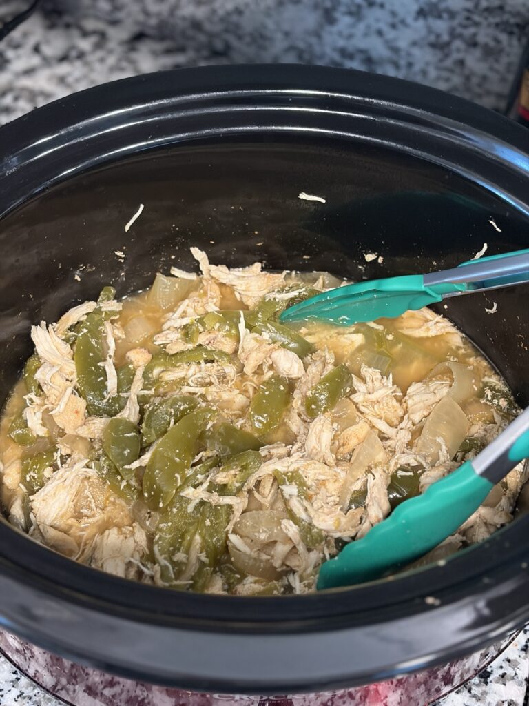 Shredded chicken with bell peppers and onions in a slow cooker